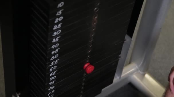 Un athlète fort met du poids sur un simulateur de bloc . — Video