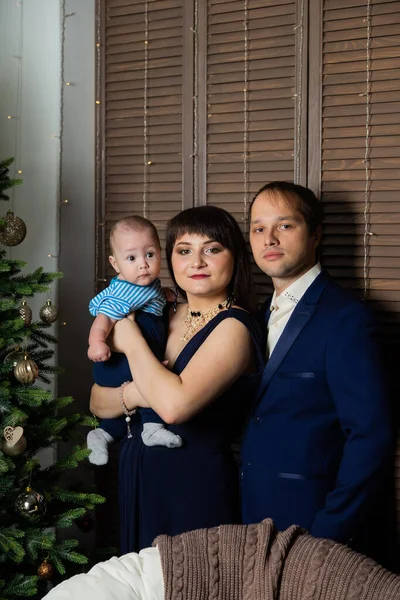 Schöne glückliche dreiköpfige Familie an Silvester. Weihnachtstreffen 2020. — Stockfoto