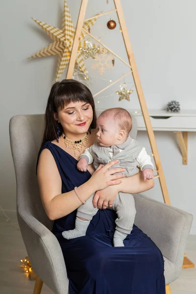 Schöne und glückliche Mutter mit einem kleinen Sohn im neuen Jahr. Weihnachtstreffen 2020. — Stockfoto