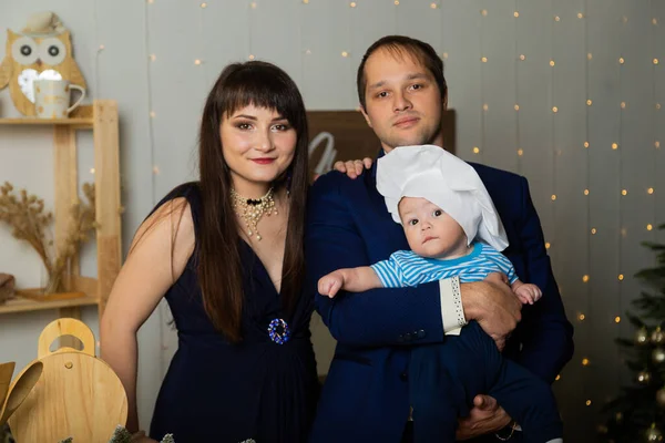 Hermosa familia feliz y joven con un niño en la cocina en el Año Nuevo . — Foto de Stock