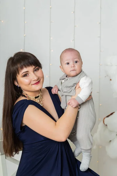 Glückliche Mutter im Abendkleid mit Kind im Fotostudio. — Stockfoto