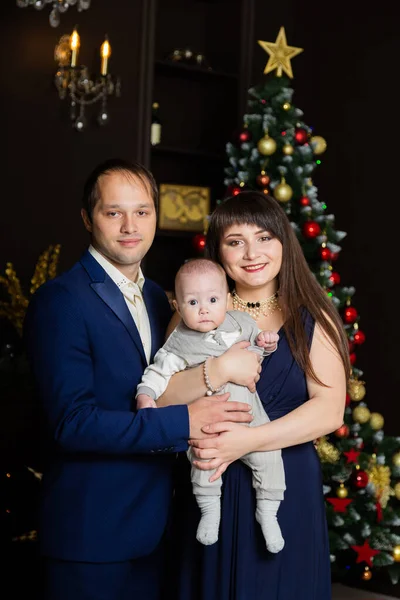 Schöne glückliche dreiköpfige Familie an Silvester. Weihnachtstreffen 2020. — Stockfoto