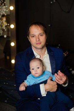 Kollarında küçük bir oğlu olan mutlu bir baba..