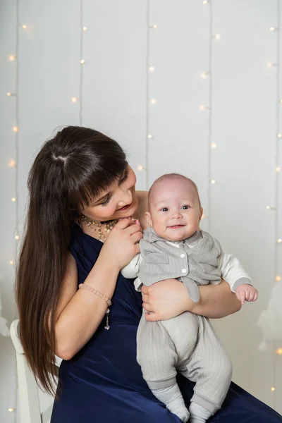 Glückliche Mutter im Abendkleid mit Kind im Fotostudio. — Stockfoto