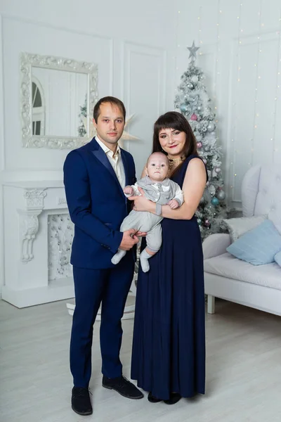 Schöne glückliche dreiköpfige Familie an Silvester. Weihnachtstreffen 2020. — Stockfoto
