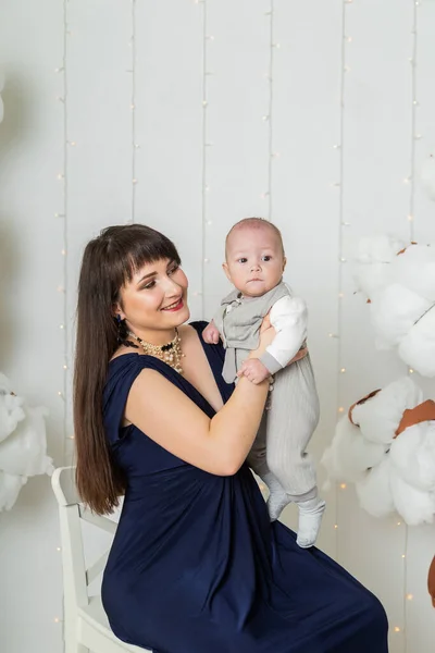 Glückliche Mutter im Abendkleid mit Kind im Fotostudio. — Stockfoto