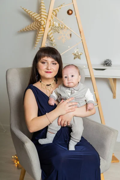 Schöne und glückliche Mutter mit einem kleinen Sohn im neuen Jahr. Weihnachtstreffen 2020. — Stockfoto