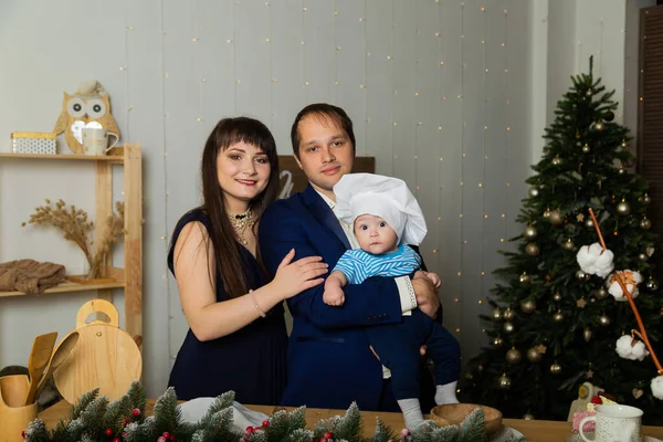 Schöne glückliche und junge Familie mit Kind in der Küche im neuen Jahr. — Stockfoto