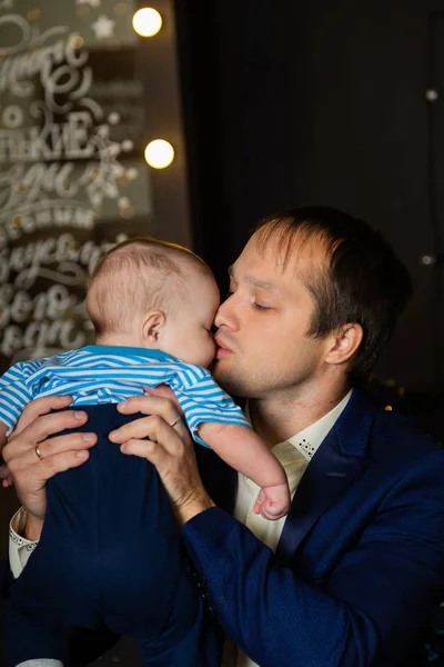 Feliz padre con un pequeño hijo en sus brazos . — Foto de Stock