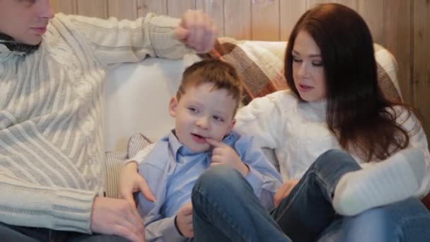 Bela e feliz pai mãe e filho no sofá em um interior moderno . — Vídeo de Stock