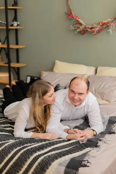 Gelukkige minnaars op het bed in een prachtig interieur. — Stockfoto