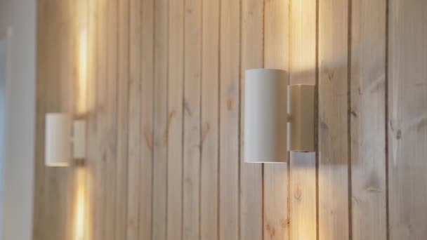 Moderne Lampen an einer Holzwand im Haus. — Stockvideo