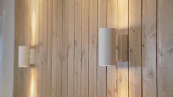 Lampes modernes sur un mur en bois dans la maison . — Video