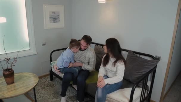 Vacker och glad pappa mamma och son på soffan i en modern inredning. — Stockvideo