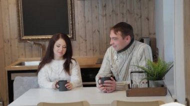 Mutfakta güzel bir kadın ve erkek modern bir iç mekanda çay içerler..