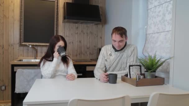 Hermoso hombre y mujer en la cocina beber té en un interior moderno . — Vídeos de Stock