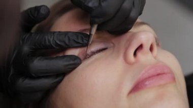 Güzellik salonunda profesyonel bir güzellik uzmanı kirpik temizleme prosedürü uygular..