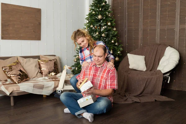 Heureux amoureux ouvrent des cadeaux pour la nouvelle année au sapin de Noël . — Photo