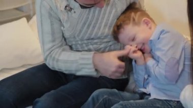 Üç kişilik mutlu bir aile Noel ağacının yanında gülümsüyor ve konuşuyor..