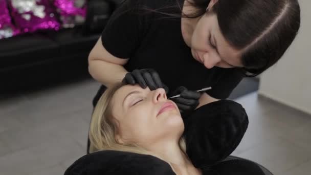 Un cosmetician profesionist într-un salon de înfrumusețare efectuează procedura de laminare a genelor . — Videoclip de stoc