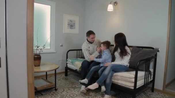 Vacker och glad pappa mamma och son på soffan i en modern inredning. — Stockvideo