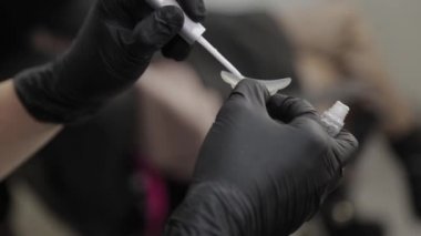 Güzellik salonundaki profesyonel güzellik uzmanı kirpik kirpikleri için silikon kaplama yapıştırıyor..