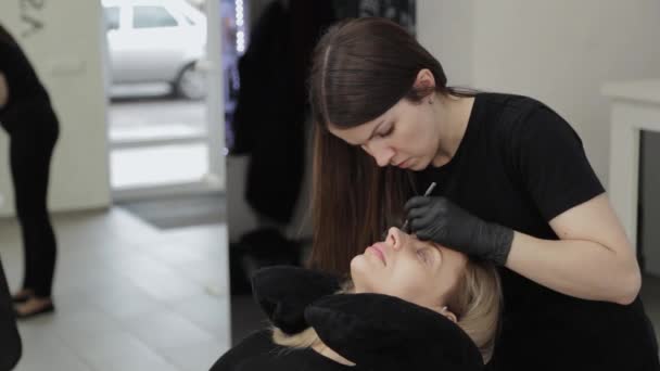 Eine professionelle Kosmetikerin in einem Schönheitssalon führt eine Wimpernlaminierung durch. — Stockvideo