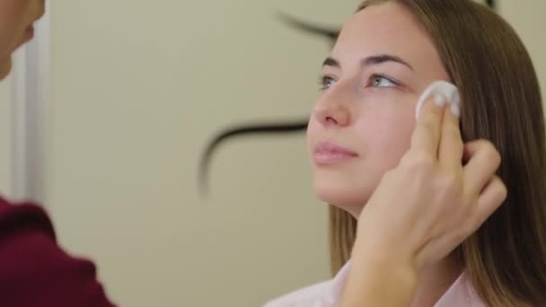 Szakmai make-up művész törli arcát ügyfél pamut törlőkendő. — Stock videók
