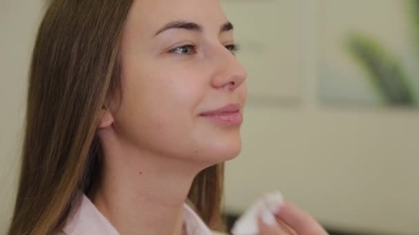 Επαγγελματική make-up καλλιτέχνης σκουπίζει το πρόσωπο του πελάτη με βαμβάκι τολύπια. — Αρχείο Βίντεο