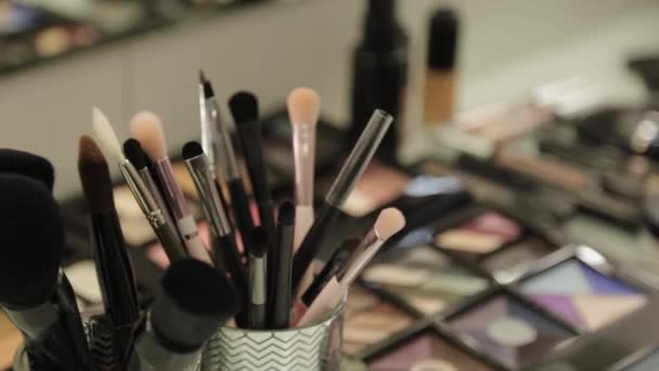 Herramientas profesionales del artista del maquillaje en una mesa en un salón de belleza . — Vídeo de stock