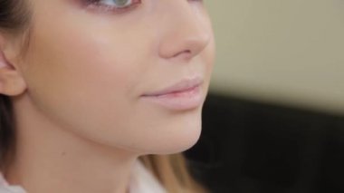 Profesyonel makyaj sanatçısı bir güzellik salonunun müşterisine makyaj yapıyor..