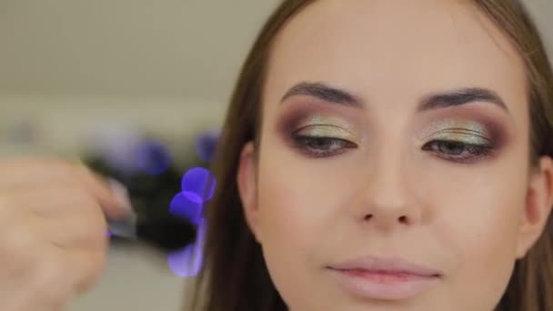 Profesjonalne makijaż artysta kładzie cień na klienta salonu piękności. — Wideo stockowe