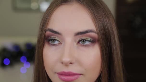 Retrato de una hermosa chica feliz con maquillaje en un salón de belleza . — Vídeos de Stock