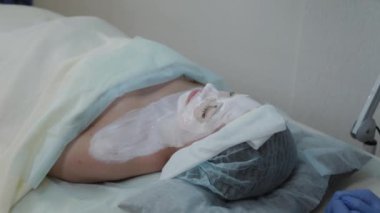 Güzel bir kadın güzellik salonunda yüzünde maskeyle yatıyor..
