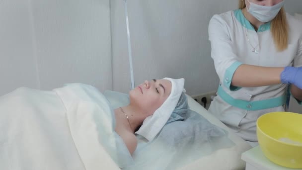 Profi kozmetikus nő dörzsöli az arcát, mielőtt az eljárás nedves törlőkendővel. — Stock videók