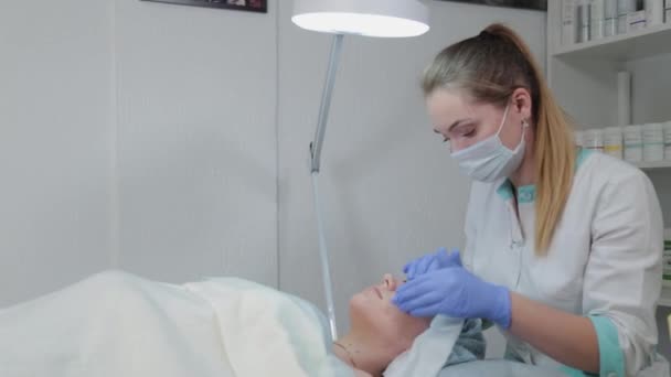 Esteticista profissional mulher massageando clientes rosto . — Vídeo de Stock