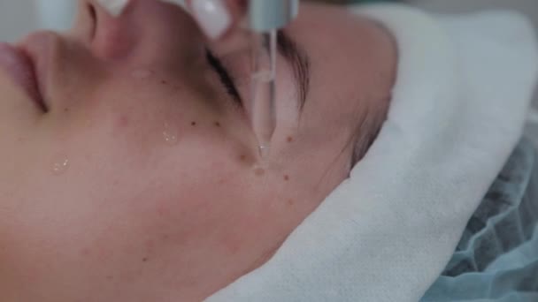 Professionelle Kosmetikerin Frau Anwendung Öl auf die Haut auf einem Keil mit einer Pipette. — Stockvideo