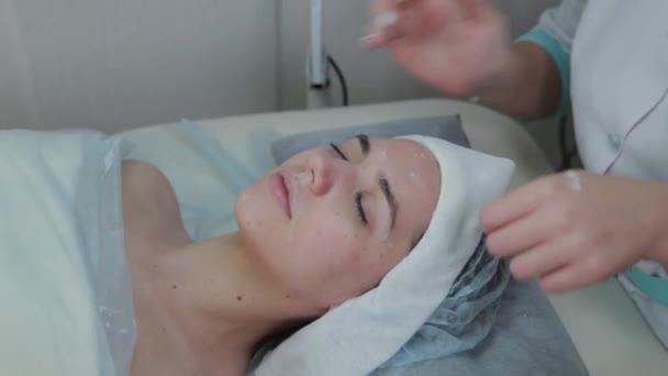 Mulher esteticista profissional realiza massagem facial para mulher cliente . — Vídeo de Stock