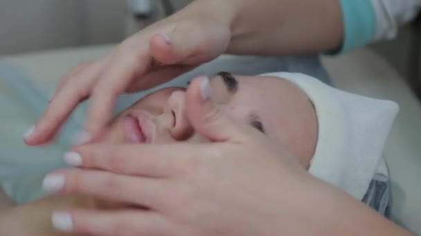 Profesjonalna kosmetyczka wykonuje masaż twarzy do kobiety klienta. — Wideo stockowe