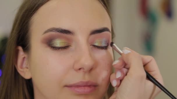 Professional makeup artist puts eye shadow on a client of a beauty salon. — Stock Video