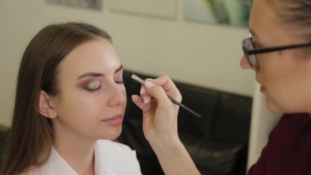 Profesionální make-up umělec klade oční stíny na klienta salonu krásy. — Stock video