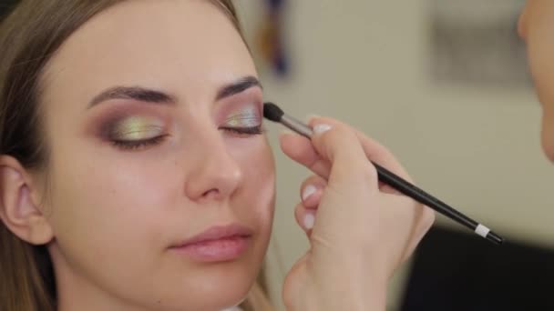 Profesionální make-up umělec klade oční stíny na klienta salonu krásy. — Stock video