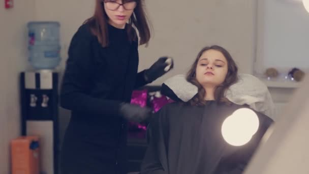 Femme professionnelle maître des sourcils nettoie les sourcils au client dans le salon de beauté . — Video