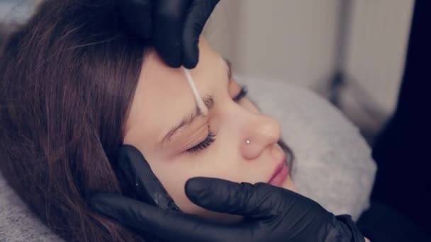 Professionell mästare browsist kvinna tillämpa gel på en bomullstuss i en skönhetssalong. — Stockvideo