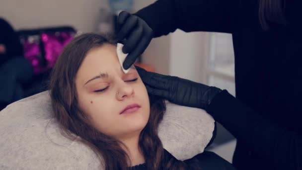 Professionell mästare browsist kvinna tillämpa gel på en bomullstuss i en skönhetssalong. — Stockvideo