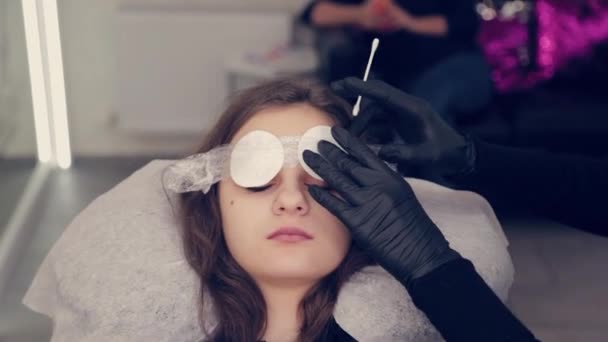 Professionnel maître sourcil femme enlève le film du sourcil et enlève le liquide sur les sourcils dans un salon de beauté . — Video