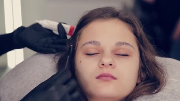 Master browsist donna professionale che applica gel su un batuffolo di cotone in un salone di bellezza . — Video Stock