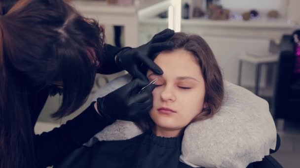 Professionelle Meister Augenbrauen Frau zupft Augenbrauen mit Pinzette Client im Schönheitssalon. — Stockvideo