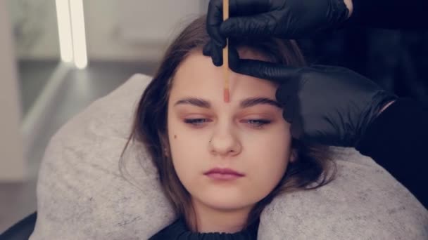 Professional master eyebrow woman doing depilation with wax eyebrow to client to client in beauty salon. — Stock Video
