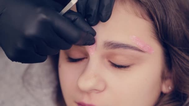 Professionell mästare ögonbrynskvinna gör depilering med vax ögonbryn till kund i skönhetssalong. — Stockvideo